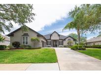 Stunning single-story home with a well-manicured lawn, mature landscaping, and a long driveway at 3716 Janus Way, Palm Harbor, FL 34685