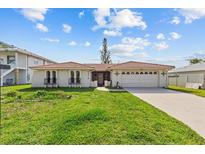 Charming single-story home with a red tile roof, a well-maintained lawn, and an attached two-car garage at 4274 Deleon Dr, Hernando Beach, FL 34607