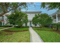 Charming two-story home with a well-manicured front yard and inviting walkway to a blue front door at 5015 S Elberon St, Tampa, FL 33611