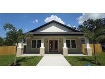 Charming single-story home with craftsman details, a welcoming porch, and a well-manicured lawn at 7013 N 15Th St, Tampa, FL 33610