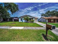 Charming single-story home with a well-maintained lawn, lovely landscaping, and an attached garage at 843 Greenfield Dr, Palm Harbor, FL 34684