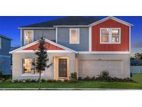 Charming two-story home with a gray and orange exterior, and a well-manicured lawn at 13040 Wellspring Dr, Lithia, FL 33547