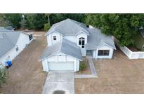 Two-story home featuring a gray roof, an attached two-car garage, and a traditional-style entrance at 13218 Parkhurst Ct, Riverview, FL 33569