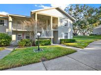 Charming condo showcasing well-maintained landscaping and a welcoming front entrance with dual balconies at 1390 Oak Hill Dr # 206, Dunedin, FL 34698