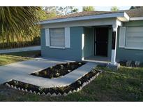 Charming single-story home with a well-manicured front yard and a quaint flower bed leading to the entrance at 3421 E Powhatan Ave, Tampa, FL 33610