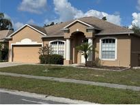 Charming single-story home with a well-manicured lawn, attached garage and inviting front entrance at 5401 Locklear Pl, Riverview, FL 33578