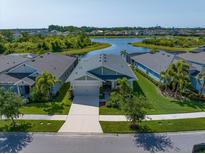 Gorgeous single-Gathering home with lake view, lush landscaping, and a well-maintained lawn at 5547 Silver Sun Dr, Apollo Beach, FL 33572