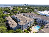 Scenic aerial view of community featuring a pool, lush landscaping, and a glimpse of the city skyline at 800 S Dakota Ave # 241, Tampa, FL 33606