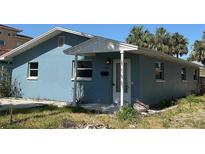 A single-story home with a blue exterior, featuring a covered front porch and a well-maintained yard at 844 Bruce Ave, Clearwater Beach, FL 33767