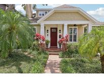 Charming home exterior featuring a brick pathway, lush landscaping, and a welcoming red front door at 1014 7Th Street N, St Petersburg, FL 33701