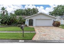 Charming single-story home with a well-maintained lawn and attractive stone driveway, showcasing curb appeal at 1313 Markley Dr, Largo, FL 33770