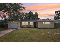 Charming one-story yellow home featuring a well-maintained lawn and welcoming front porch area at 1450 Seabreeze St, Clearwater, FL 33756