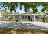Charming single-story home with a well-maintained front yard, a cozy porch, and a spacious driveway at 1489 77Th N Ave, St Petersburg, FL 33702