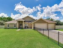 Beautiful single-story home with a well-manicured lawn and three-car garage, secured by an elegant fence at 16220 Lake Armistead Way, Odessa, FL 33556