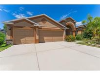 Charming single-story home with a well-manicured lawn, a spacious driveway, and a two-car garage at 2637 Yukon Cliff Dr, Ruskin, FL 33570