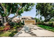 Charming home featuring lush landscaping, a driveway, and an attached two-car garage at 3174 Eagles Landing W Cir # 58, Clearwater, FL 33761