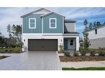 Charming two-story home featuring a two-car garage, blue siding, and a well-maintained front yard at 37255 Sagemoor Dr, Zephyrhills, FL 33541
