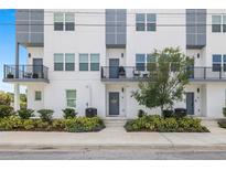 Modern townhome exterior with white facade, gray accents, balconies, and landscaped entrance at 4120 W North A St # 2, Tampa, FL 33609