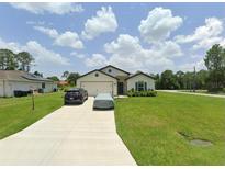 Charming single-story home with a well-manicured lawn and paved driveway at 5407 Kedgewick Ln, North Port, FL 34288
