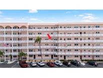 Multi-story condo building with several units, palm trees, and parking at 6025 Shore S Blvd # 409, Gulfport, FL 33707