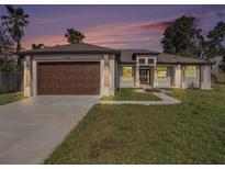 Beautiful single-story home with a well-maintained lawn, a two-car garage and manicured landscaping at 9416 Bullfrog Court, Gibsonton, FL 33534
