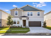 Charming two-story home with a well-manicured lawn and a covered front porch at 9981 Surrey Rose Dr, San Antonio, FL 33576
