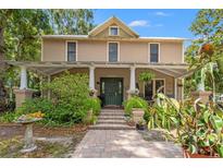 Charming two-story home with a welcoming front porch and lush landscaping at 1001 E Crawford St, Tampa, FL 33604
