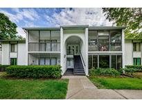 Inviting condo exterior featuring screened porches and lush landscaping, offering a blend of privacy and outdoor living at 1170 Pine Ridge W Cir # C2, Tarpon Springs, FL 34688