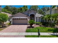 Charming single-Gathering home with a well-maintained front yard, beautiful landscaping, and a two-car garage at 16219 Nottingham Park Way, Tampa, FL 33647