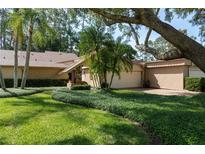Charming home featuring well-manicured landscaping and mature trees with a two car garage at 3071 Bolt Dr, Palm Harbor, FL 34685