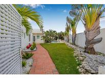 Beautiful backyard featuring a brick pathway, lush landscaping, and glimpses of a refreshing pool at 321 N Boulevard Of The Presidents, Sarasota, FL 34236
