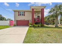 Charming two-story home with a red-colored garage door and a cozy front porch at 3227 Rose Arbor Dr, Hernando Beach, FL 34607