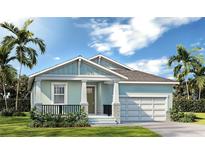 Inviting single-story home showcases a light blue exterior, complemented by a charming porch and lush landscaping at 3720 Rocky Island Rd, New Port Richey, FL 34655