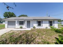 Charming single-story home with a freshly painted white exterior and well-manicured front yard at 5341 Tangerine Dr, Zephyrhills, FL 33542
