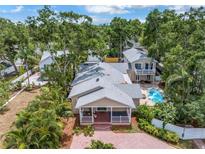 Beautiful home with lush landscaping, brick driveway, covered porch, and a sparkling swimming pool in the backyard at 546 26Th N Ave, St Petersburg, FL 33704