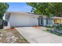 Charming single-story home featuring an attached garage, arched entryway, and well-maintained landscaping at 7215 San Moritz Dr, Port Richey, FL 34668