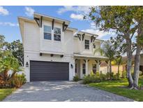 Charming two-story home with a gray brick driveway, dark gray garage door, and attractive landscaping at 807 W Kentucky Ave, Tampa, FL 33603