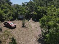 A lot of land partially cleared, has trash cans and an abandoned truck at 8601 N 28Th St, Tampa, FL 33604
