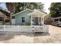 Charming home with a white picket fence, front porch, and manicured landscaping at 945 8Th N St, St Petersburg, FL 33712