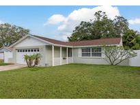 Charming single-story home with a well-maintained lawn, attached garage, and inviting front porch at 11991 104Th Ave, Seminole, FL 33778