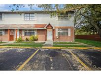 Exterior view of townhome featuring brick and siding, white trimmed windows and doorway with parking available at 12780 N 57Th St, Tampa, FL 33617