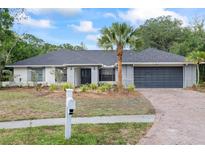 Charming one story home featuring grey brick, a brick driveway, landscaping, and a mailbox at 16014 Amberly Dr, Tampa, FL 33647