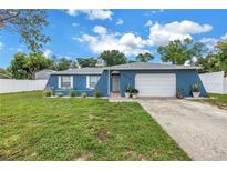 Charming single-story home with a well-manicured lawn, blue facade, and inviting curb appeal at 2270 Amherst Ave, Spring Hill, FL 34609