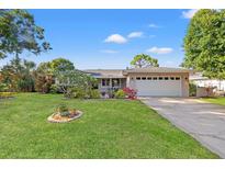 Charming home with a well-manicured front yard, lush landscaping, and a two-car garage, creating curb appeal at 2701 65Th Ave S, St Petersburg, FL 33712