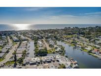 Scenic aerial view of waterfront homes along canals leading to the ocean under a clear blue sky at 28 Seaside Ct, Holmes Beach, FL 34217
