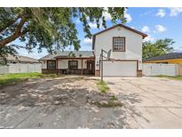 Two-story home with a white exterior, brown trim, and a front yard with a basketball hoop at 3104 Apricot St, Seffner, FL 33584