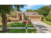 Charming single-story home with a well-manicured lawn, brick accents, and an attached two-car garage at 3922 Cedar Cay Circle, Valrico, FL 33596
