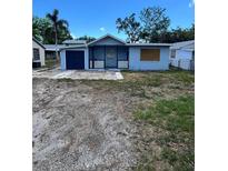 Modest single-story home featuring light blue paint and a dark blue garage door at 3950 45Th N Ave, St Petersburg, FL 33714