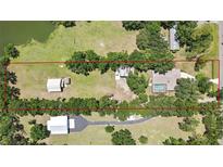 Expansive property with a serene pond, spacious main house with pool, and versatile outbuildings offering ample space at 4706 Scott Rd, Lutz, FL 33558
