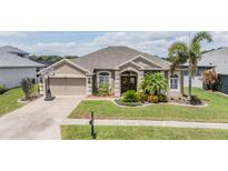 Charming single-story home with a well-manicured lawn and a two-car garage at 5049 Rushbrook Rd, Land O Lakes, FL 34638